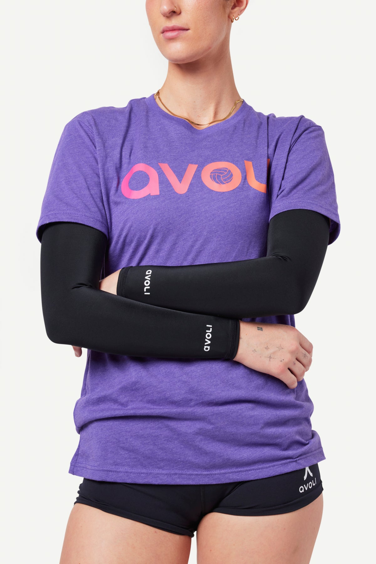 Person wearing a purple 'Avoli' t-shirt and black arm sleeves on a white background