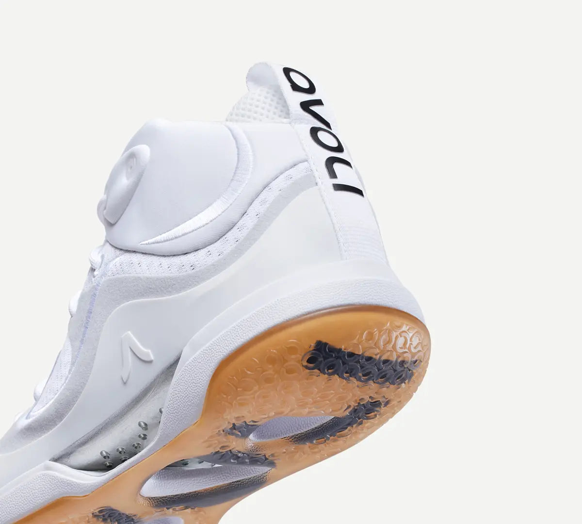 Heel view of a white mid-top volleyball shoe with a gum-colored sole