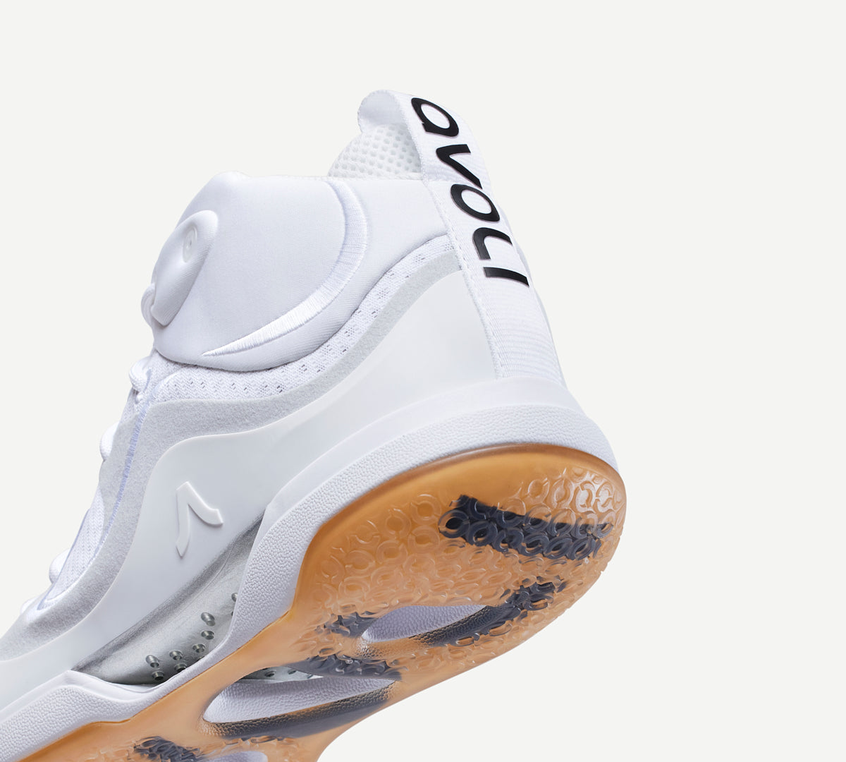 Heel view of a white mid-top volleyball shoe with a gum-colored sole