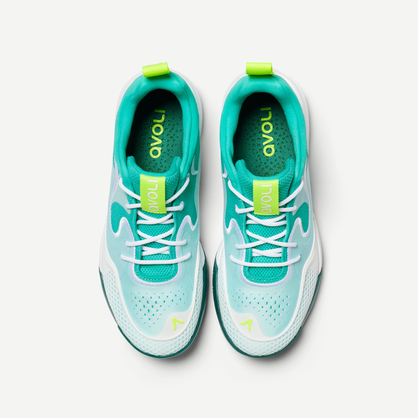 A pair of white and green volleyball shoes with reinforced toe protection and superior traction designed for court play.