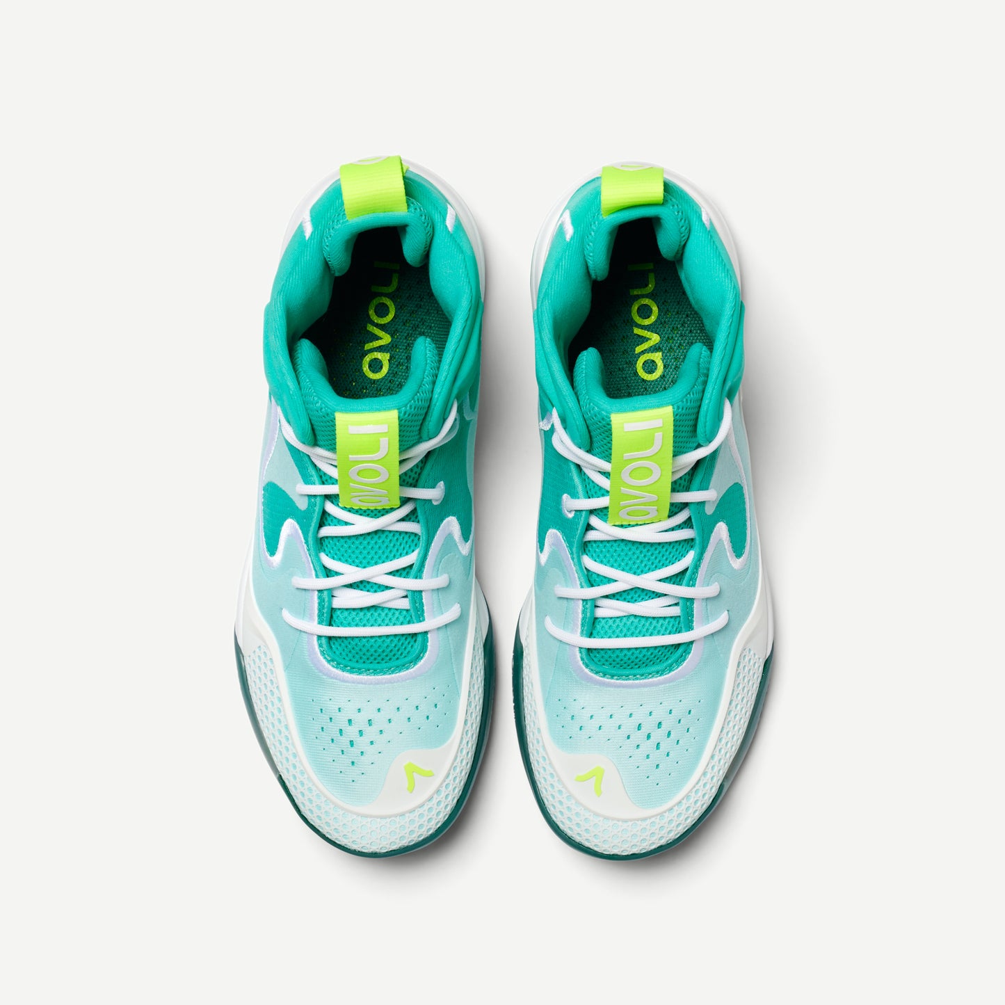 A volleyball shoe with a white and green color scheme, featuring a mid-top design with Avoli branding on the side.