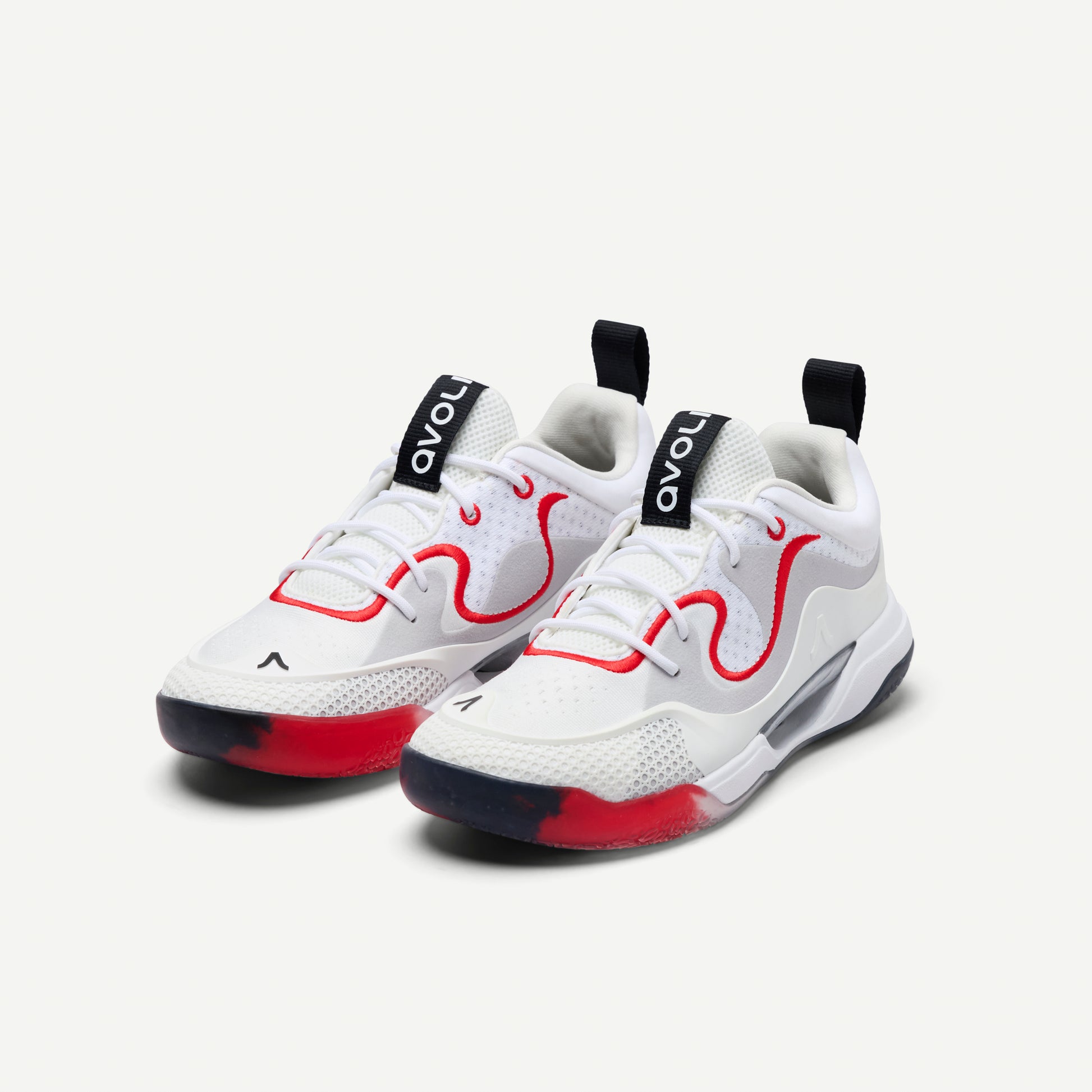 White sneakers with red and black accents on a white background
