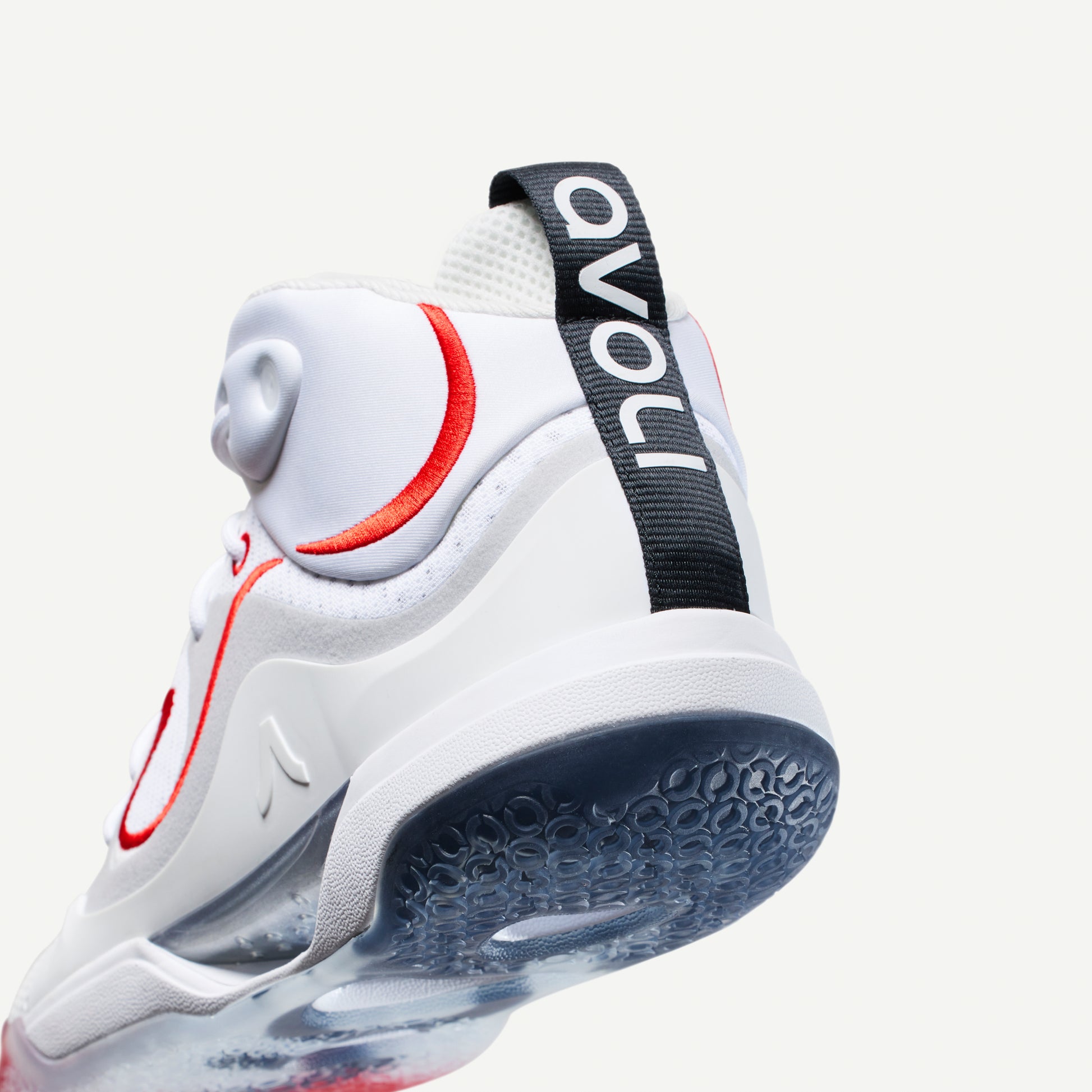 White mid-top volleyball sneaker with red accents on a white background